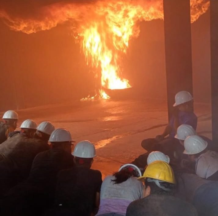 Participantes observando una práctica controlada de prevención y combate de incendios